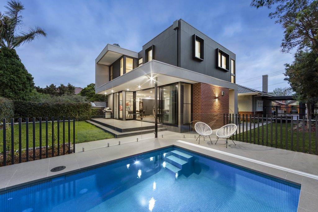 Maison contemporaine avec piscine éclairée en soirée