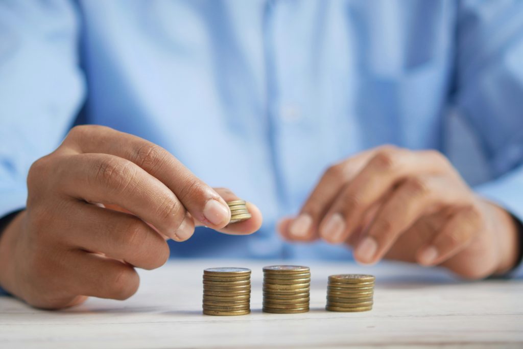 Mains empilant des pièces de monnaie en colonnes sur une table
